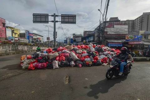 Tumpukan sampah yang dibiarkan begitu saja pada median jalan di kawasan Ciputat, Tangerang selatan, Banten, Senin (15/12/2025).