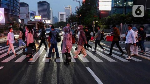 Karyawan perkantoran berjalan kaki  bergegas pulang di Kawasan Sudirman, Jakarta, Rabu (30/11/2022). Keputusan Pemerintah Provinsi (Pemprov) DKI Jakarta menaikan upah minimum provinsi (UMP) D
