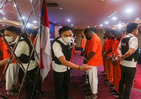 Petugas Imigrasi saat mengamankan warga negara asing yang terjaring Operasi Wirawaspada 2025 saat konpers di Gedung Direktorat Jenderal Imigrasi, Jakarta Selatan, Selasa (16/12/2025).