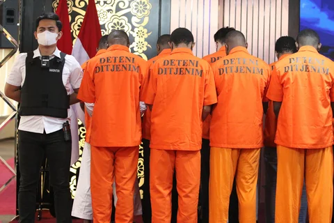 Petugas Imigrasi saat mengamankan warga negara asing yang terjaring Operasi Wirawaspada 2025 saat konpers di Gedung Direktorat Jenderal Imigrasi, Jakarta Selatan, Selasa (16/12/2025).