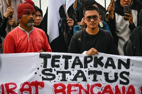 Massa dari berbagai elemen yang tergaabung dalam Aksi Koalisi Masyarakat Sipil Aceh melakukan aksi unjuk rasa di depan Masjid Raya Baiturrahman, Banda Aceh, Kamis (18/12/2025).