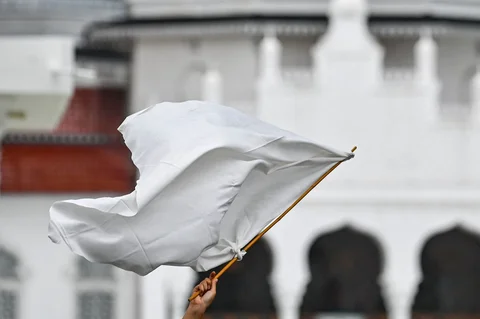 Massa dari berbagai elemen yang tergaabung dalam Aksi Koalisi Masyarakat Sipil Aceh melakukan aksi unjuk rasa di depan Masjid Raya Baiturrahman, Banda Aceh, Kamis (18/12/2025).