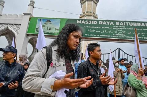 Massa dari berbagai elemen yang tergaabung dalam Aksi Koalisi Masyarakat Sipil Aceh melakukan aksi unjuk rasa di depan Masjid Raya Baiturrahman, Banda Aceh, Kamis (18/12/2025).
