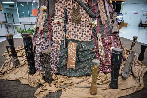 Dekorasi Natal sepanjang 63 meter bermotif budaya Papua yang dibuat dengan bantuan AI dan dihiasi Tifa, perisai Asmat, serta ornamen tradisional di Universitas Petra Surabaya, Kamis (18/12/2025).