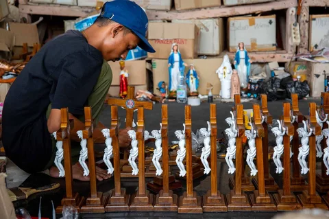 Seorang pekerja menyelesaikan pembuatan patung keagamaan Kristen di bengkel kerajinan Studio Malta Jaya di Bantul, Yogyakarta, Kamis (18/12/2025).