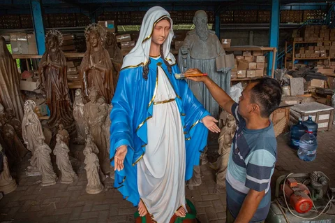 Seorang pekerja menyelesaikan pembuatan patung keagamaan Kristen di bengkel kerajinan Studio Malta Jaya di Bantul, Yogyakarta, Kamis (18/12/2025).