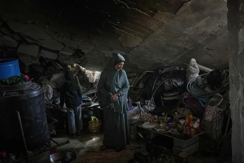 Khadija Abu Shaqfa dan putrinya Rita berjalan melewati dapur rumah mereka yang rusakdi, Kota Gaza, Jumat (21/11/2025).