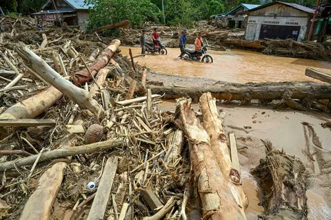 Warga berjalan di tengah banjir bandang di Desa Tukka, Tapanuli Tengah, Provinsi Sumatera Utara, Selasa (02/12/2025).