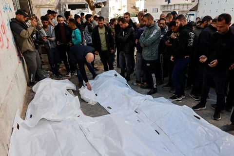 Para pelayat berdiri di sisi jenazah anggota keluarga Al-Nader yang dilaporkan tewas sehari sebelumnya akibat serangan Israel terhadap sekolah yang dijadikan tempat perlindungan di kawasan Tuffah, Kota Gaza, Sabtu (20/12/2025).