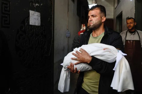 Seorang kerabat membawa jenazah Ahmed Al-Nader, bayi berusia lima bulan yang dilaporkan tewas bersama anggota keluarganya dalam serangan Israel terhadap sekolah yang dijadikan tempat perlindungan di kawasan Tuffah, Kota Gaza, Sabtu (20/12/2025).