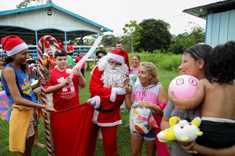 Relawan Jorge Alberto Barrozo, yang mengenakan kostum Sinterklas, mengantarkan hadiah kepada anak-anak di komunitas tepi sungai di daerah pedesaan Careiro da Varzea, negara bagian Amazonas, Brasil, Sabtu (20/12/2025) waktu setempat.