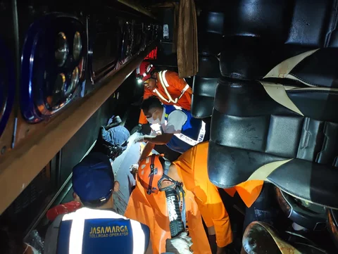 Petugas Basarnas mengevakuasi penumpang meninggal usai kecelakaan bus PO Cahaya Trans di ruas simpang susun exit tol Krapyak Kota Semarang, Senin (22/12/2025).