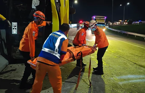 Petugas Basarnas mengevakuasi penumpang meninggal usai kecelakaan bus PO Cahaya Trans di ruas simpang susun exit tol Krapyak Kota Semarang, Senin (22/12/2025).