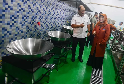 Kepala BGN Dadan Hindayana bersama, bersama Ketua Umum Pemberdayaan Perempuan UMKM Indonesia (PPUMI), Munifah Syarwani menyaksikan dapur Satuan Pelayanan Pemenuhan Gizi, (SPPG) saat Grand Lunching Nasional SPPG Terintegrasi di Lapangan Dapur SPPG-MBG kawasan Tanah Sareal Kota Bogor, Jawa Barat, Selasa (23/12/2025).