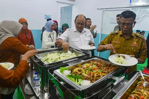 Kepala BGN Dadan Hindayana mencoba makan bergizi gratis saat Grand Lunching Nasional SPPG Terintegrasi di Lapangan Dapur SPPG-MBG kawasan Tanah Sareal Kota Bogor, Jawa Barat, Selasa (23/12/2025).