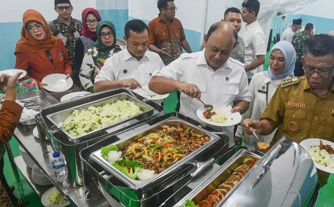 Kepala BGN Dadan Hindayana mencoba makan bergizi gratis saat Grand Lunching Nasional SPPG Terintegrasi di Lapangan Dapur SPPG-MBG kawasan Tanah Sareal Kota Bogor, Jawa Barat, Selasa (23/12/2025).