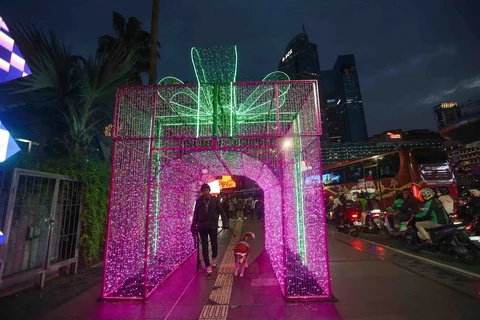 Warga menikmati suasana Jakarta Light Festival 2025 di sekitar Bundaran Hotel Indonesia, Jakarta, Selasa (23/12/2025).