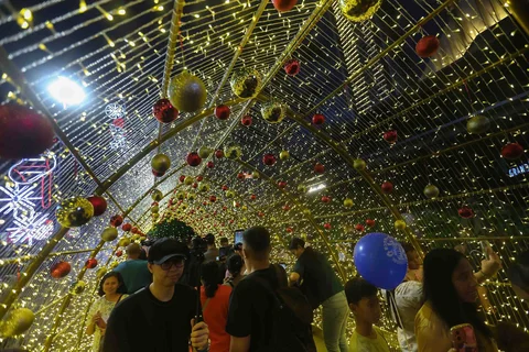 Warga menikmati suasana Jakarta Light Festival 2025 di sekitar Bundaran Hotel Indonesia, Jakarta, Selasa (23/12/2025).