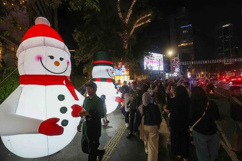 Warga menikmati suasana Jakarta Light Festival 2025 di sekitar Bundaran Hotel Indonesia, Jakarta, Selasa (23/12/2025).