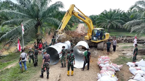 Personel Kodim 0104/Aceh Timur bersama Yonif TP 853/Bawar Reje Bur saat menyelesaikan pembangunan jembatan Armco di Dusun Leupon, Gampong Bukit Kuta, Aceh Timur, Selasa (23/12/2025).