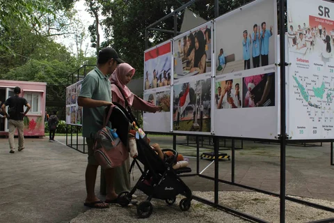 Pengunjung menyaksikan beragam karya jurnalistik dalam pameran Haluan Merah Putih Roadshow yang digelar di Selasar Kantin Taman Margasatwa Ragunan, Jakarta Selatan, Selasa (24/12/2025).