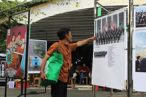 Pengunjung menyaksikan beragam karya jurnalistik dalam pameran Haluan Merah Putih Roadshow yang digelar di Selasar Kantin Taman Margasatwa Ragunan, Jakarta Selatan, Selasa (24/12/2025).