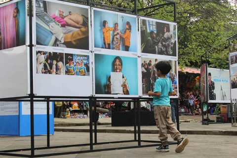 Pengunjung menyaksikan beragam karya jurnalistik dalam pameran Haluan Merah Putih Roadshow yang digelar di Selasar Kantin Taman Margasatwa Ragunan, Jakarta Selatan, Selasa (24/12/2025).