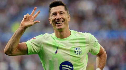 Penyerang Barcelona, Robert Lewandowski melakukan selebrasi setelah mencetak gol ketiganya pada pertandingan sepak bola Liga Spanyol melawan Deportivo Alaves di stadion Mendizorroza, Vitoria, Minggu 6 Oktober 2024. (Cesar Manso/AFP)
