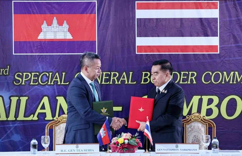 Menteri Pertahanan Kamboja Tea Seiha (kiri) dan Menteri Pertahanan Thailand Nattaphon Narkphanit (kanan) berjabat tangan dan bertukar dokumen saat pertemuan khusus Komite Perbatasan Umum (GBC) di pos pemeriksaan perbatasan di provinsi Chanthaburi, Thailand. Sabtu (27/12/2025).