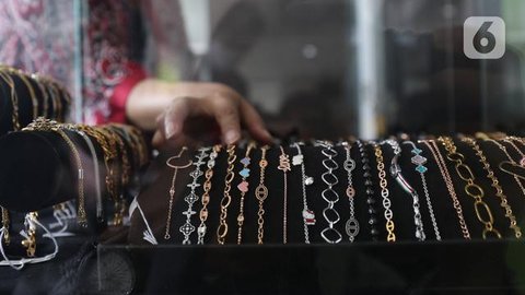 Seorang pelanggan memegang perhiasan emas selama festival Hindu 'Akshaya Tritiya', hari keberuntungan dalam kalender Hindu untuk membeli barang-barang berharga, di ruang pamer perhiasan di