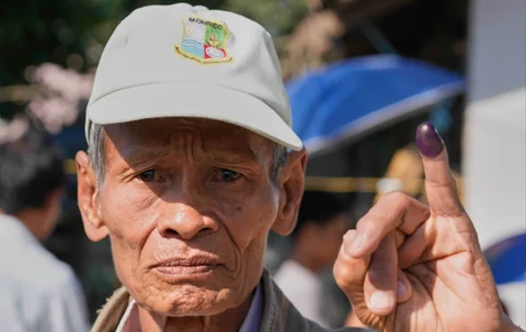 Seorang pemilih mengangkat jarinya yang ditandai dengan tinta untuk menunjukkan bahwa ia telah memilih, di sebuah tempat pemungutan suara di Naypyitaw, Myanmar, Minggu, (28/12/2025).