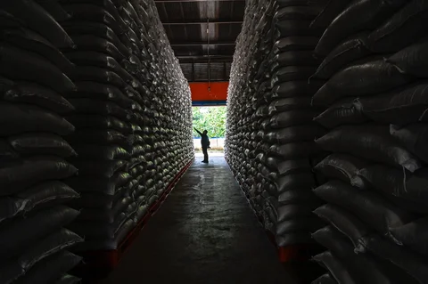 Pekerja memeriksa tumpukan beras di gudang Badan Logistik Indonesia (Bulog) di Lambaro, Provinsi Aceh, Senin (29/12/2025).