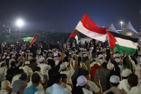 Warga membacakan sholawat nabi saat mengikuti Reuni 212 di Monas, Jakarta, Selasa (2/12/2025) malam.