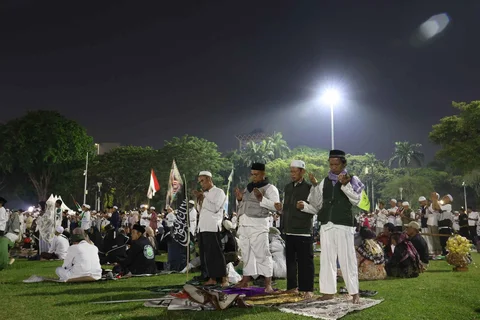 Warga membacakan sholawat nabi saat mengikuti Reuni 212 di Monas, Jakarta, Selasa (2/12/2025) malam.