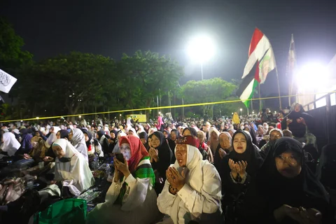 Warga membacakan sholawat nabi saat mengikuti Reuni 212 di Monas, Jakarta, Selasa (2/12/2025) malam.