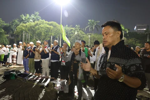 Warga membacakan sholawat nabi saat mengikuti Reuni 212 di Monas, Jakarta, Selasa (2/12/2025) malam.