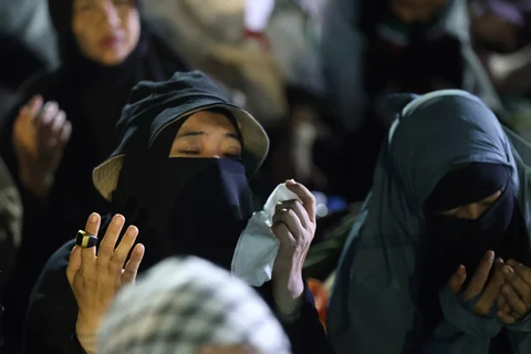 Warga berdoa saat mengikuti Reuni 212 di Monas, Jakarta, Selasa (2/12/2025) malam.