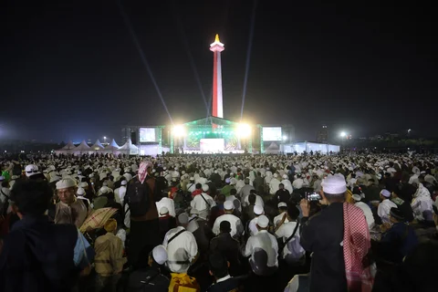 Warga membacakan sholawat nabi saat mengikuti Reuni 212 di Monas, Jakarta, Selasa (2/12/2025) malam.