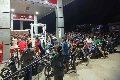 Warga yang selamat dari banjir mengantre untuk mendapatkan bensin di sebuah SPBU di Batang Toru, Sumatera Utara, Indonesia, Selasa (02/12/2025).