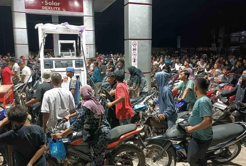 Warga yang selamat dari banjir mengantre untuk mendapatkan bensin di sebuah SPBU di Batang Toru, Sumatera Utara, Indonesia, Selasa (02/12/2025).