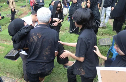 Istri almarhum bersama anak saat pemakaman aktor senior Epy Kusnandar di Taman Pemakaman Umum Jeruk Purut, Jakarta Selatan, Kamis (4/12/2025).