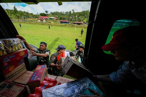 Warga membawa bantuan yang didistribusikan helikopter  TNI AU di wilayah terdampak banjir di Kabupaten Bener Meriah, Provinsi Aceh,Kamis (04/12/2025).