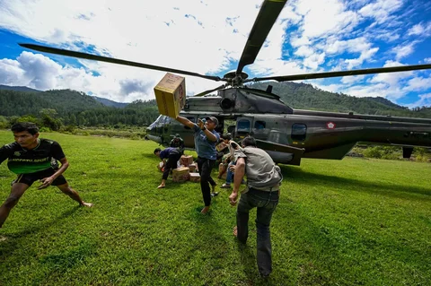 Warga membawa bantuan yang didistribusikan helikopter  TNI AU di wilayah terdampak banjir di Kabupaten Bener Meriah, Provinsi Aceh,Kamis (04/12/2025).