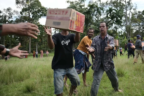 Tentara dan warga menurunkan barang bantuan dari helikopter Badan Nasional Penanggulangan Bencana (BNPB) saat distribusi bantuan udara di wilayah terdampak banjir di Aceh Utara, Indonesia, Kamis (04/12/2025).