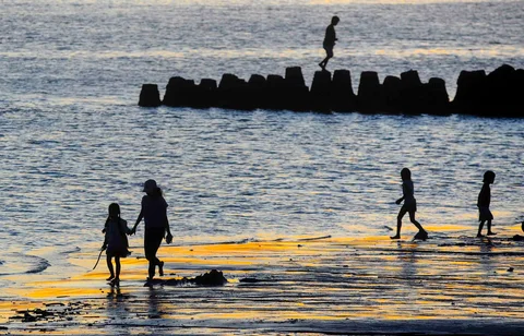 Wisatawan beraktifitas menjelang senja di Pantai Kelan, Badung, Bali