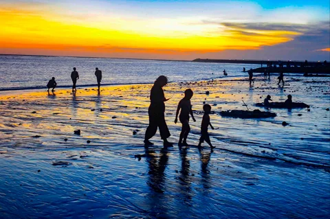 Wisatawan beraktifitas menjelang senja di Pantai Kelan, Badung, Bali