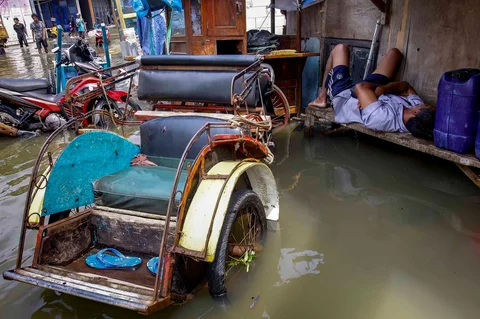 Warga tertidur saat banjir rob  di Muara Baru, Jakarta, Sabtu (06/12/2025).