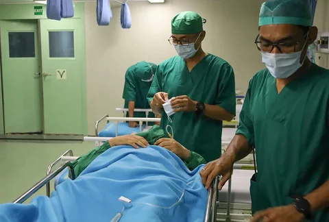 Tim medis TNI AL saat melakukan tindakan operasi kepada warga Sibolga yang mengalami luka pascabencana banjir bandang di atas kapal KRI dr. Radjiman Wedyodiningrat di Sibolga, Sumatera Utara, Sabtu (06/12/2025).