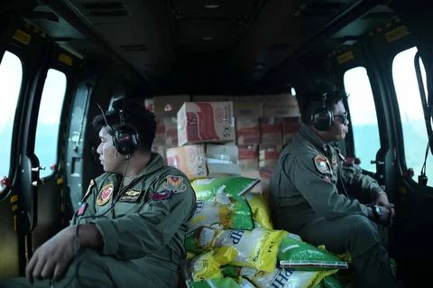 Personel Skadron Udara 8 TNI AU  duduk di dalam helikopter untuk mendistribusikan bantuan ke daerah terdampak banjir di Aceh Tengah, Indonesia, Sabtu (06/12/2025).