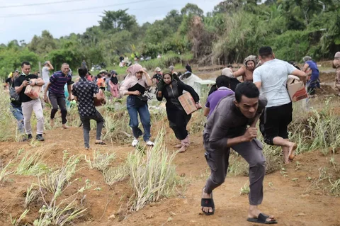 Warga saat mendapatkan  bantuan kemanusiaan di daerah terdampak banjir di Aceh Tengah, Indonesia, Sabtu (06/12/2025).
